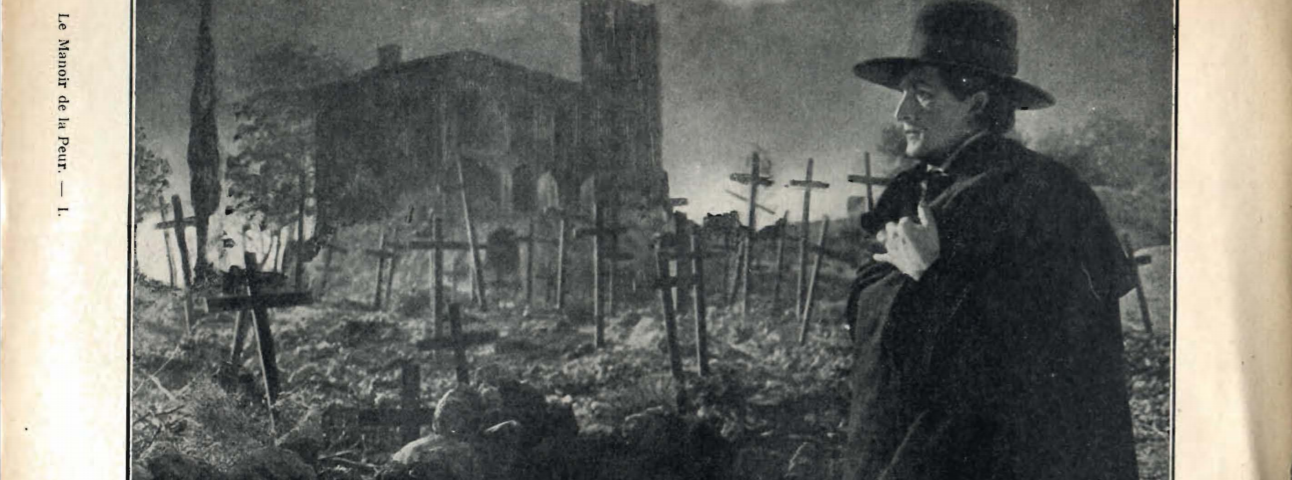 A stranger with a macfarlane and a big hat is seen standing in front of a cemetary of wooden crosses and a church.