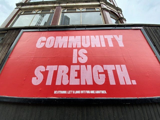 red and white sign that says community is strength