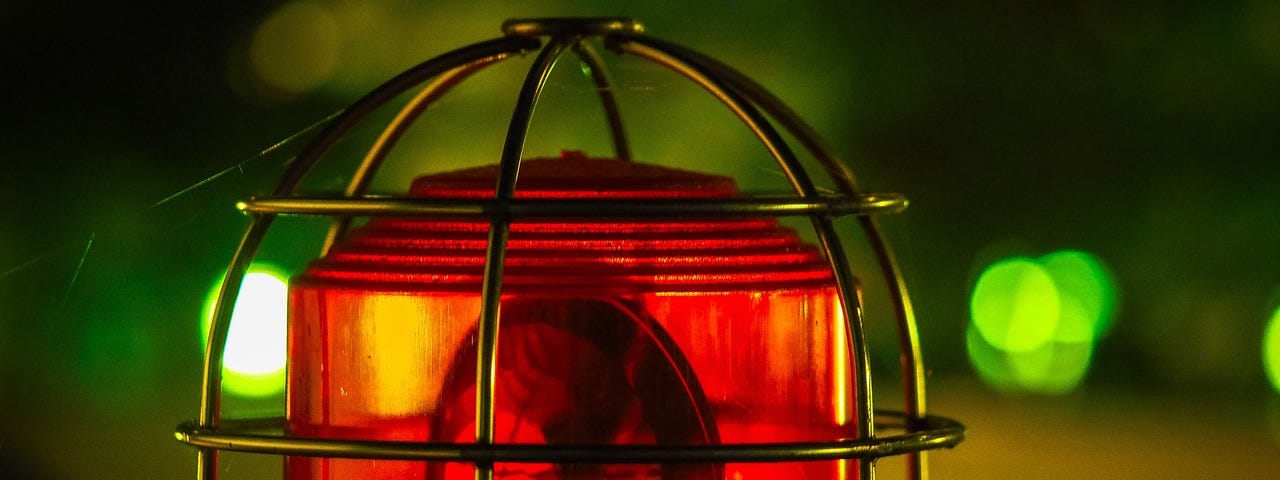 Image shows a red emergency light in a gold-colored wire cage on top of an emergency vehicle.