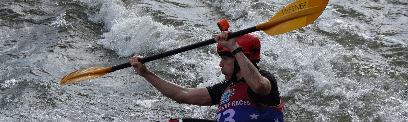 The author whitewater kayaking in a slalom race