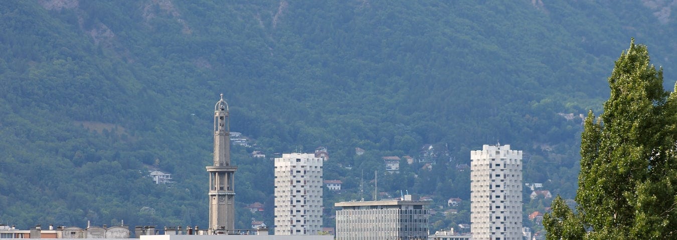 View of the skyline of the city of Grenoble, France, with greenery in the foreground