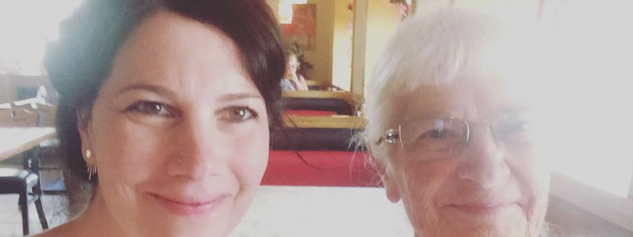 A close-up selfie of the author and her elderly mother sitting in a booth at a restaurant. There is a white glare from the window that obscures part of the mother’s face.