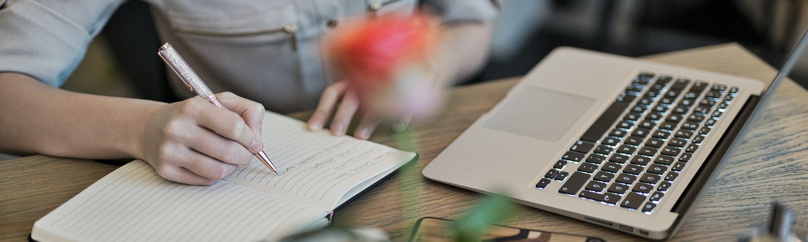 Photo by Judit Peter: https://www.pexels.com/photo/person-writing-on-a-notebook-beside-macbook-1766604/