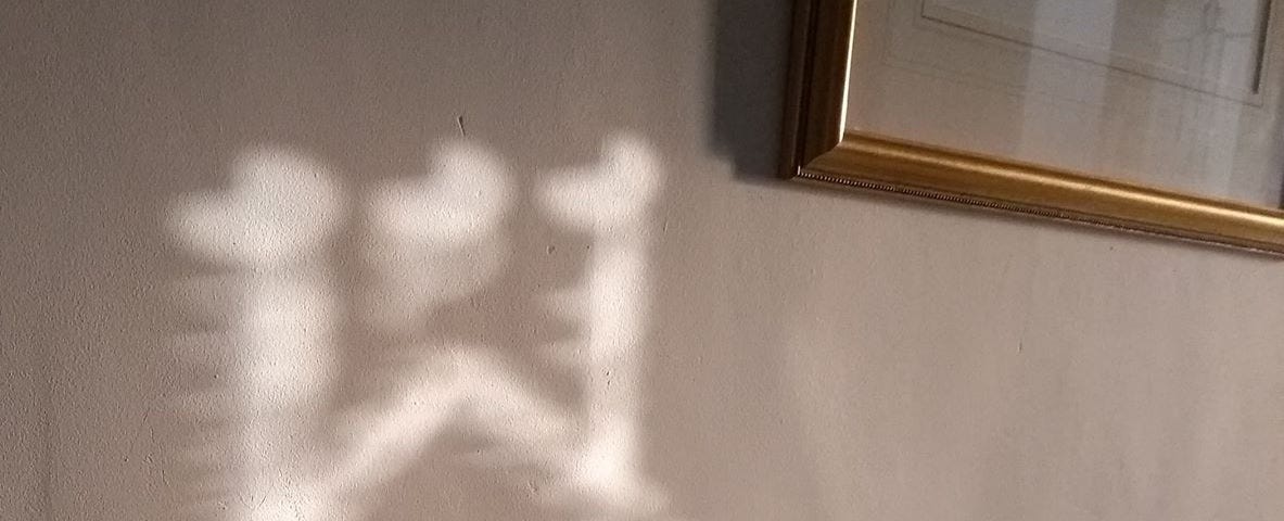 A pattern of light on the left and the corner of a picture frame on the right.