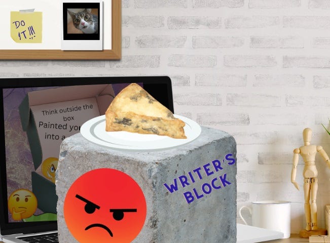 Photo of a desk with an open laptop. A large cement block sits on the keyboard with the words “Writer’s Block” written on one side, and angry emoji face on the other side, and a plate with a piece of moldy pie on top.