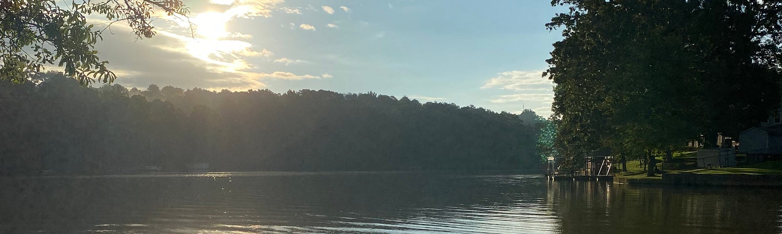 Sunlight peeks through clouds to shimmer on a lake.