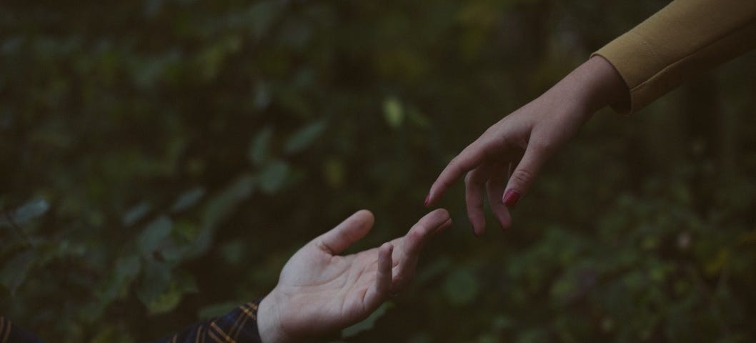 Two hands reach for one another against a background of greenery. The Mutual Ground Rules for Leaving a Bad Relationship.