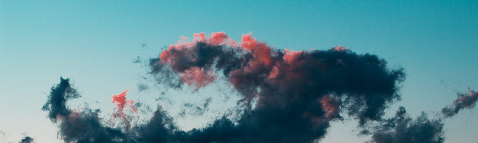 Clouds floating in the blue/orange colored sky.