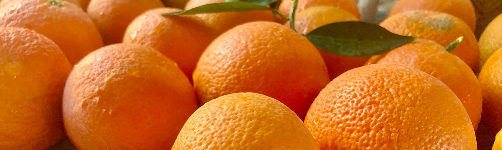 A collection of fresh oranges sit on a blue cloth