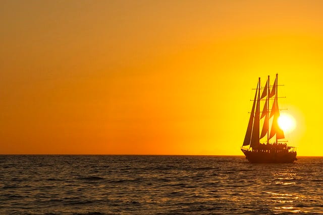 Sailing ship with the sun setting.