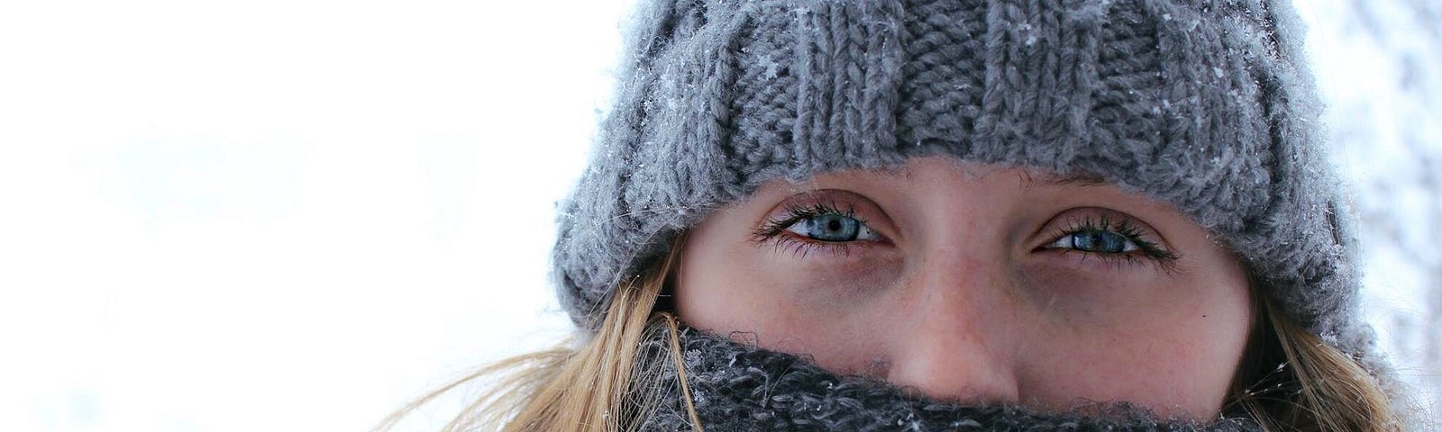 Young woman bundled up in snow, closeup