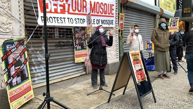 Sister Nermeen at a weekly Saturday protest in January 2021 in front of mosque on Branford Pl, signage with white background and red writing “hands off! our mosque — protest to stop the sale of mosque”