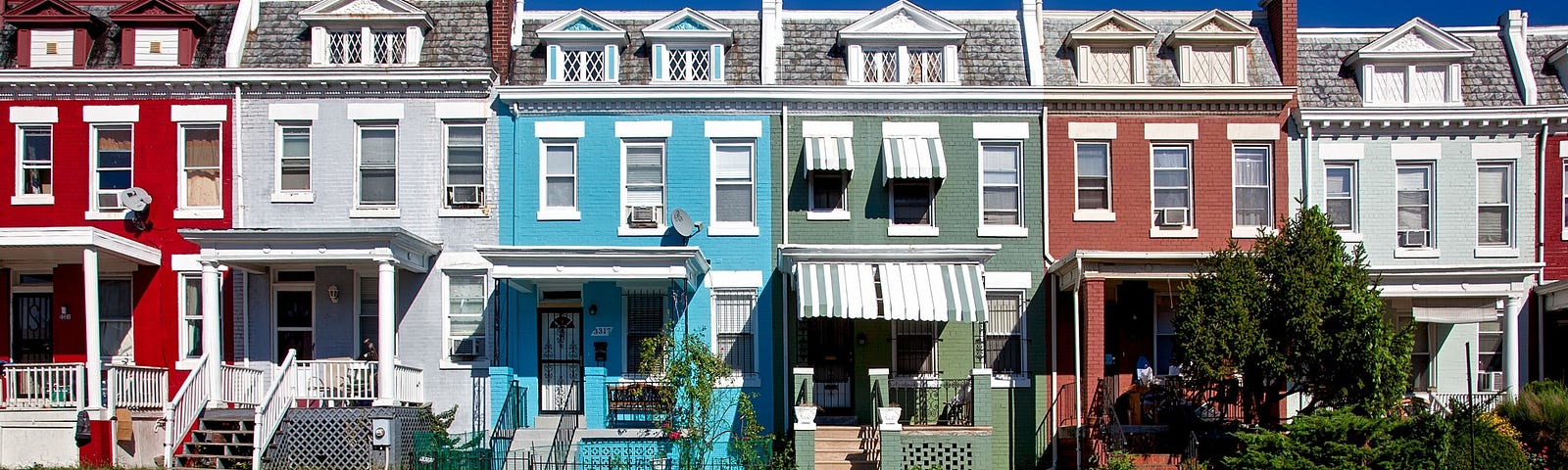 Red, silver, blue, and green row houses in an American city