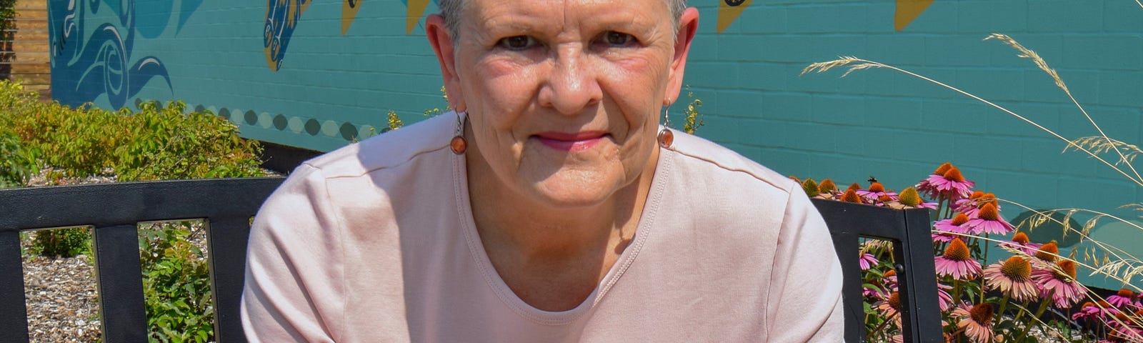 Woman in a pink shirt against a blue mural wall