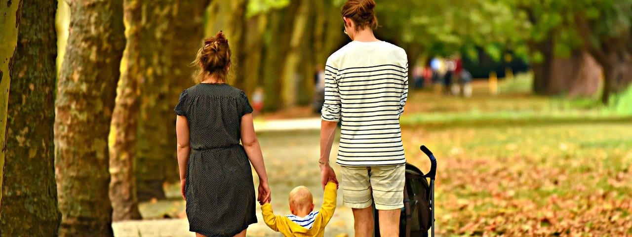 Parents walking with child between them.