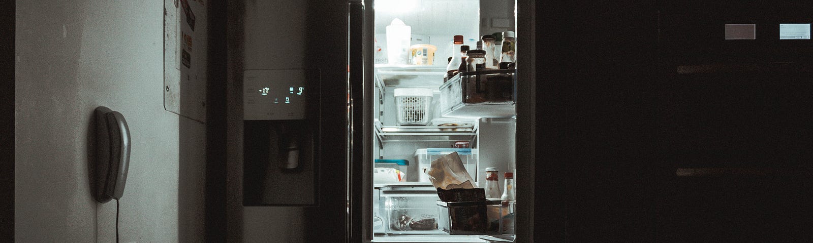 Open fridge in a dark kitchen.