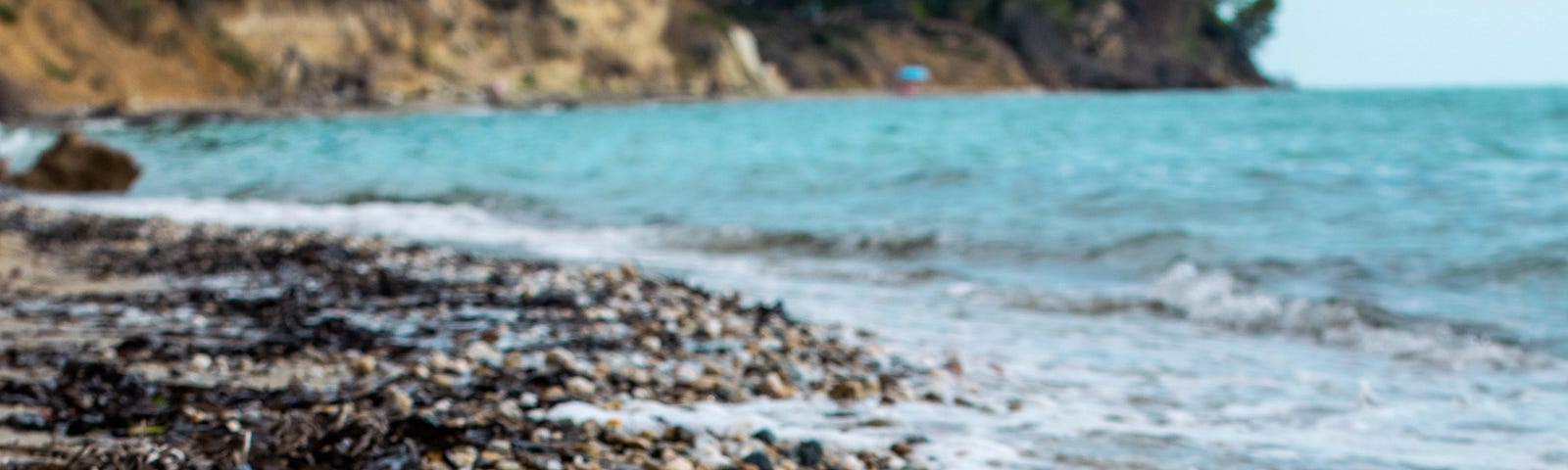 A pebbled beach, a blue sea.