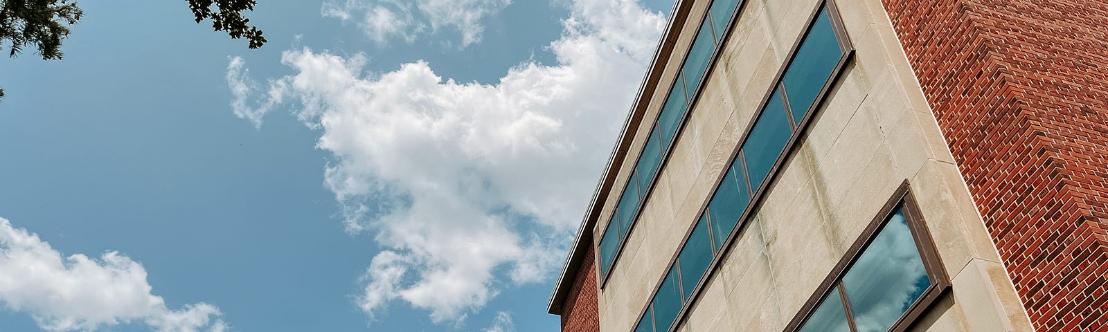 Clouds in the sky reflect in the windows of Canfield Administration Building