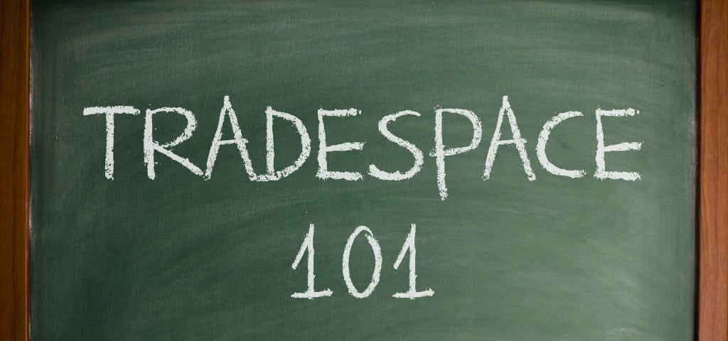 A green chalkboard with “Tradespace 101” written on it in white chalk