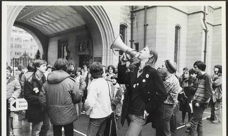 Photograph of students protesting outside the Queen’s Arch, Oxford Road.