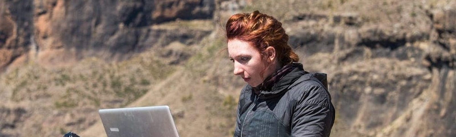 A woman using her laptop outdoors.