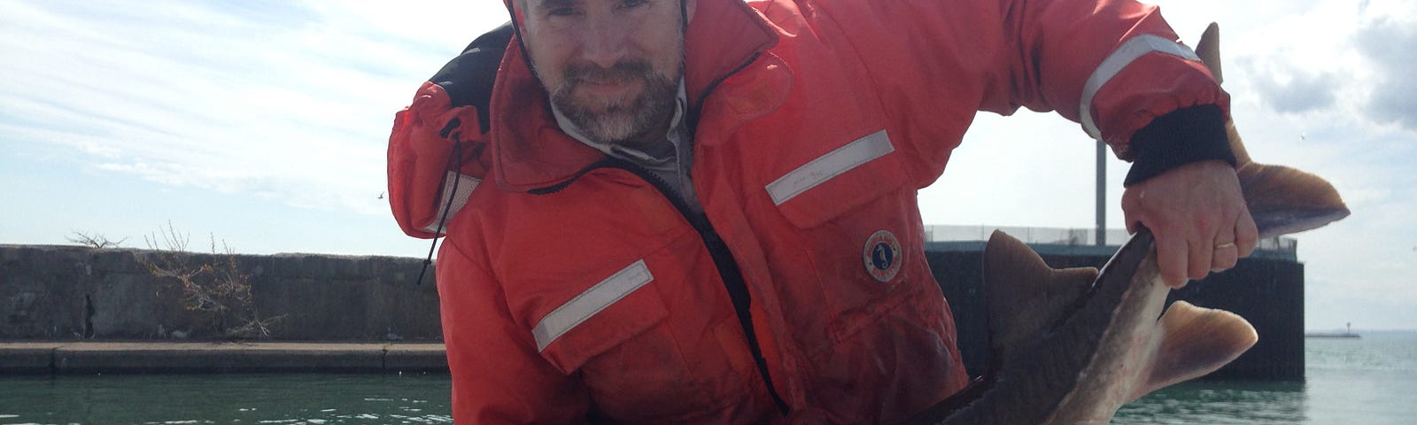 John Sweka holding an adult lake sturgeon (Acipenser fulvescens) captured in Lake Erie and fitted with a pop-off satellite archival tag (PSAT).