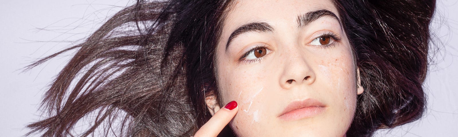 Woman applying a skincare treatment to her face