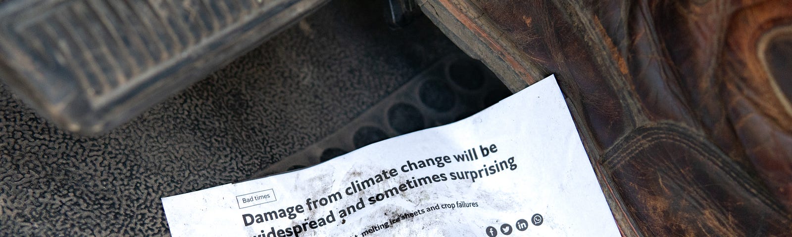 Work boot stepping on article about climate change.