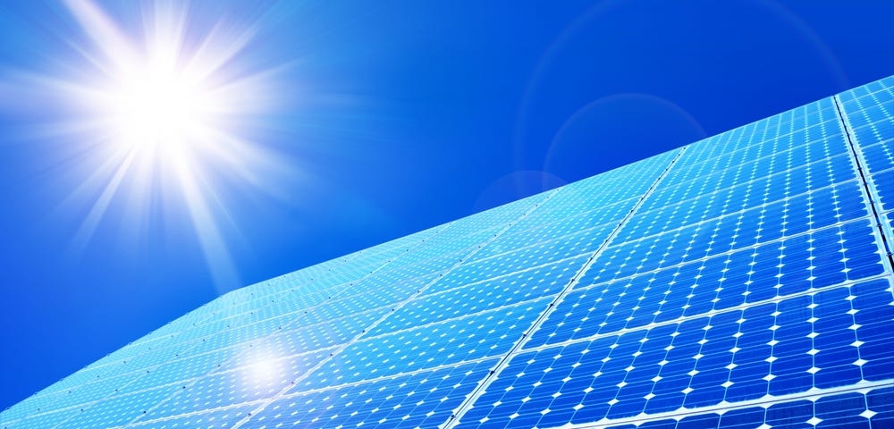 Picture of solar panels with a bright shining sun