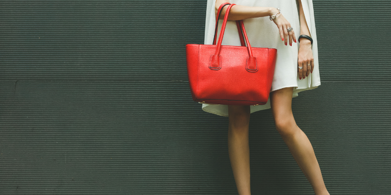 A woman holding a red purse, for my article “Dear Men, Let’s Stop Saying We “Bagged” a Woman”