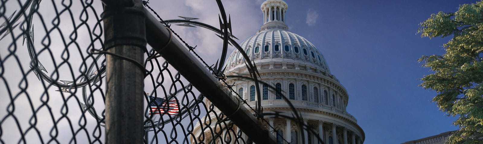 The dome of the U.S. Capitol Building behind a chain-link fence with razor wire. Photo by John Webb/Getty Images