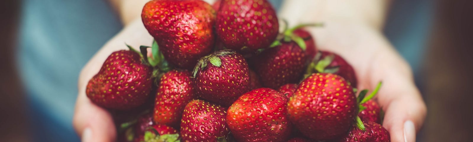 A photo of handfuls of delicious strawberries by Artur Rutkowski on Unsplash