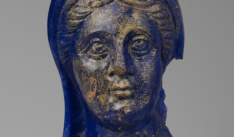 Blue glass head of woman with gold spattering