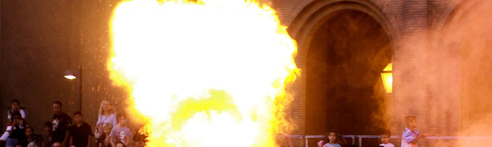 A fire breather performing to a crowd