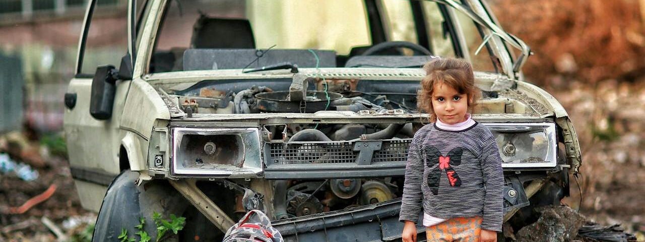 Girl standing in a war-torn area.