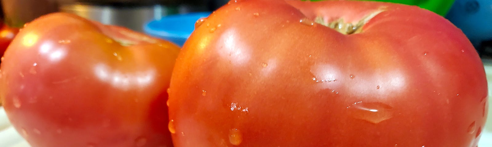 Two rinced Mortgage lifter tomatoes on a white cutting board