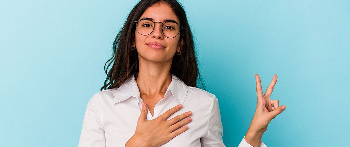 young-caucasian-woman-isolated-blue-background-taking-oath-putting-hand-chest — Un Swede