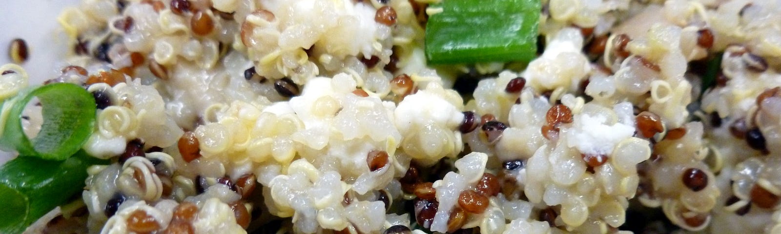 Cooked tri-color quinoa with green onions and feta cheese.