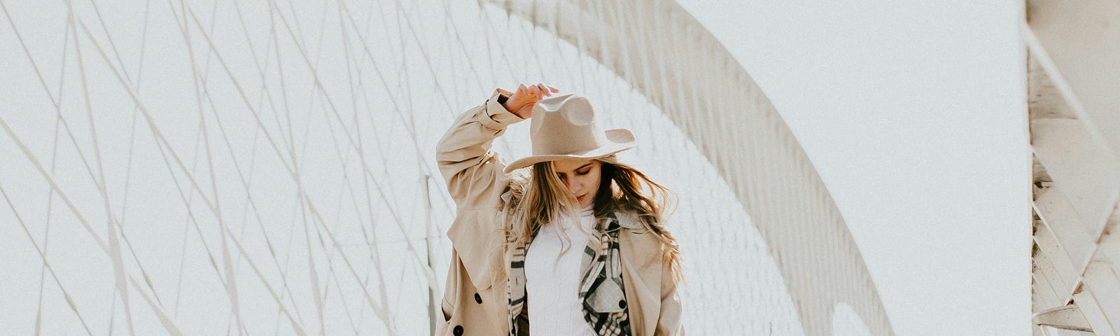 A girl dressed in alternative/ boho style walking across a bridge.