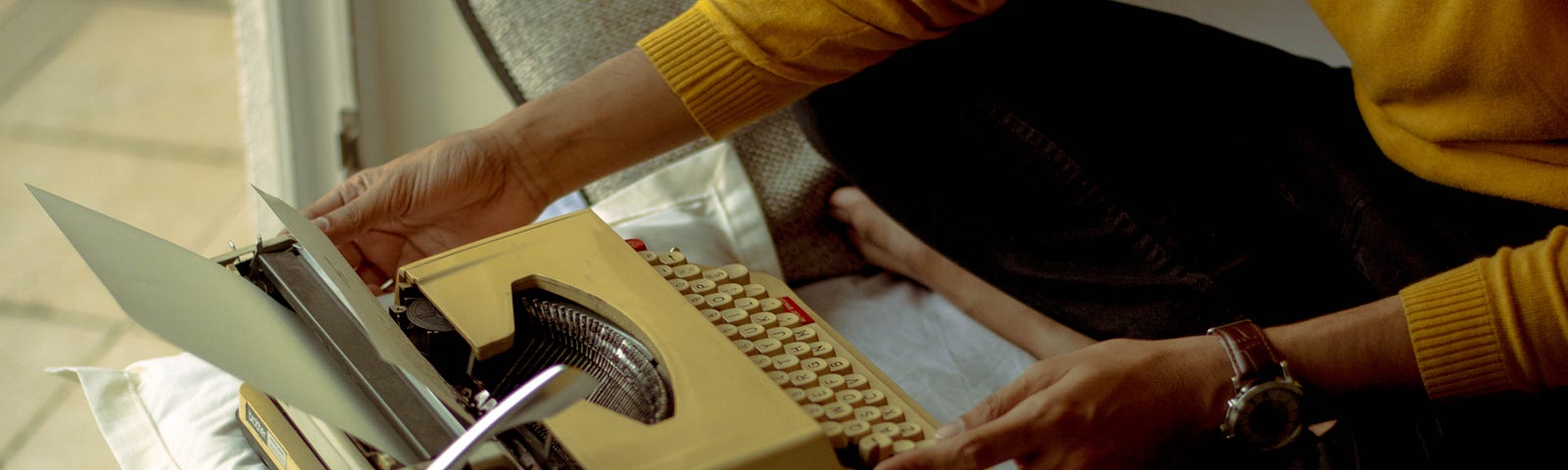 Person using a yellow vintage typewriter