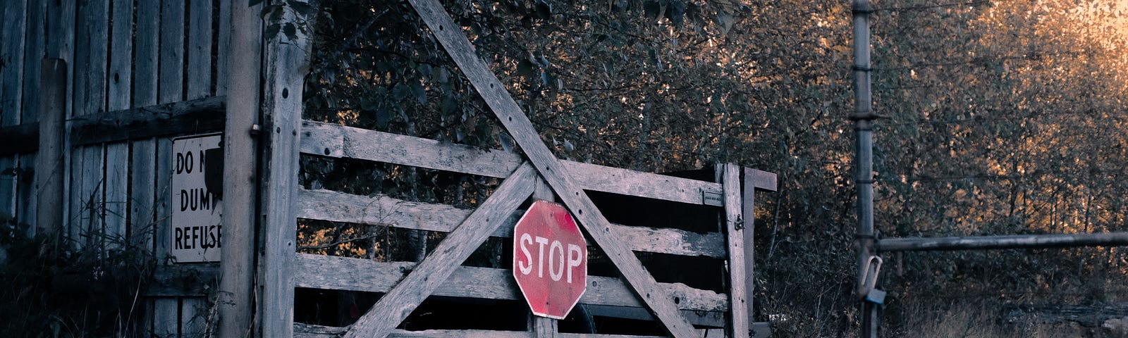 Photo of stop sign on fence in rural town
