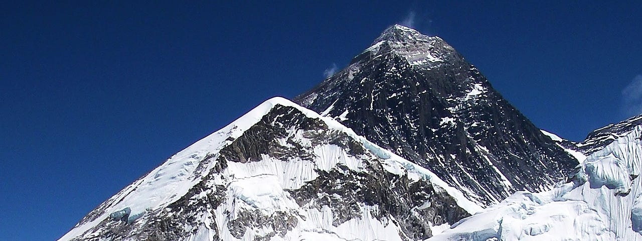 An image of snowy mountain peaks and deep blue sky.