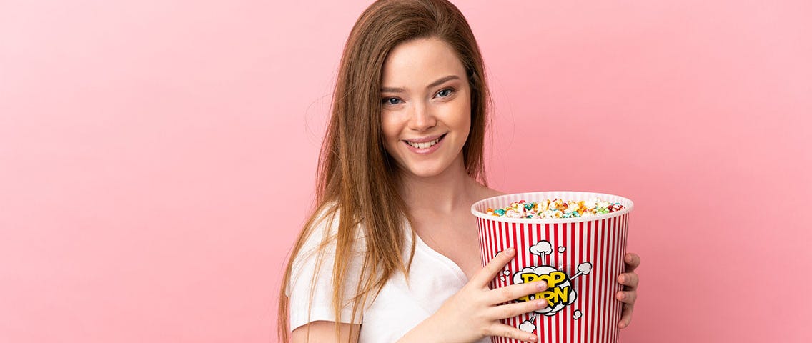 teenager-girl-isolated-pink-background-holding-big-bucket-popcorns — Un Swede