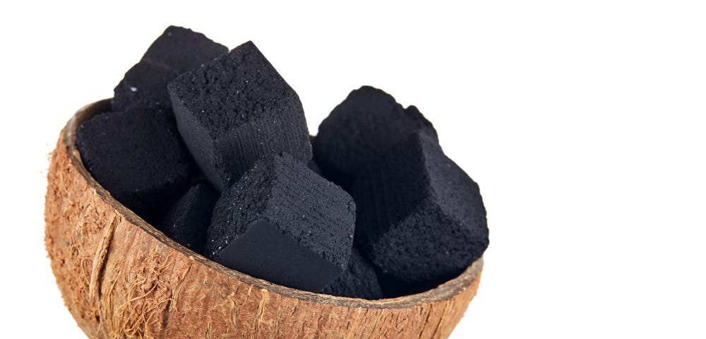 Picture of a coconut bowl filled with charcoal made from coconut leftovers