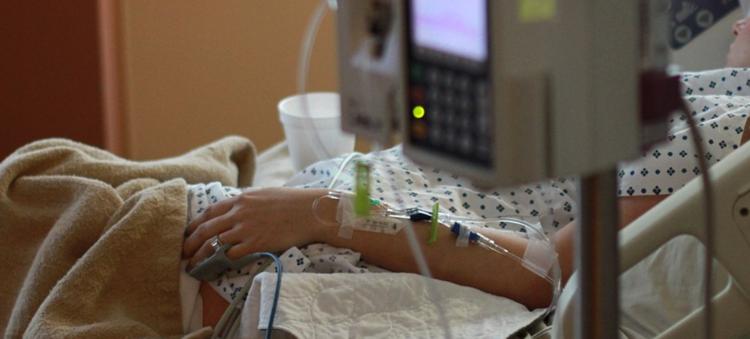 woman in hospital bed with IV line