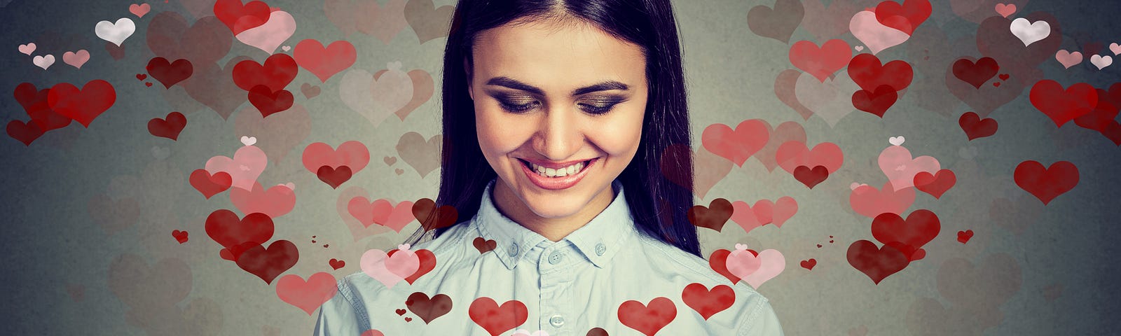 A woman using her cell phone with pink and red hearts surrounding it (dating apps, relationships, relationship studies, addicted to dating apps)