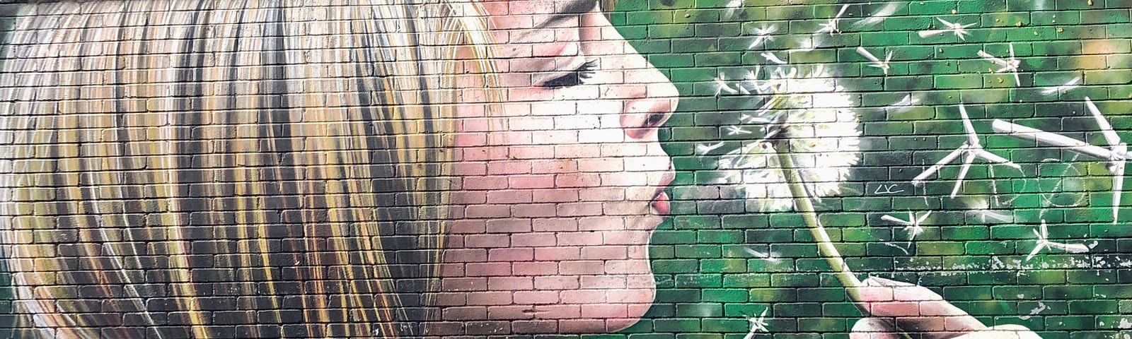 A wall mural depicting a young woman blowing a dandelion “clock”, but with tiny wind turbines in place of dandelion seeds.