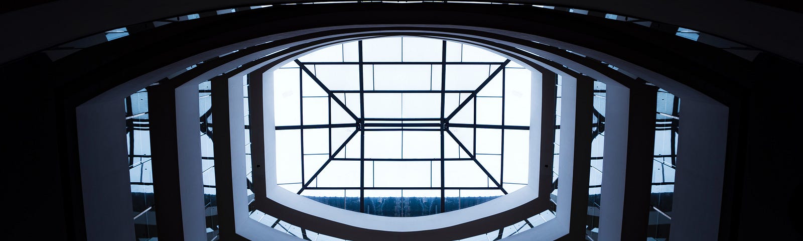 Geometric building interior showing multiple floors leading to skylight