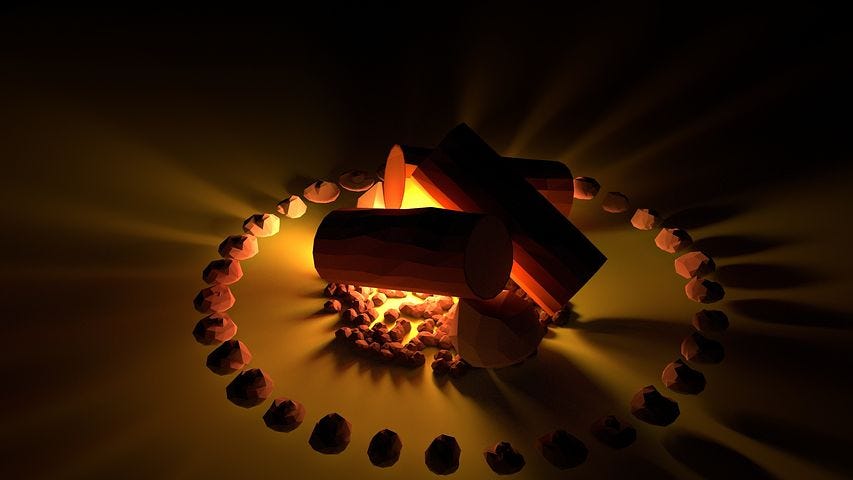 A campfire alight and surrounded by a ring of rocks.