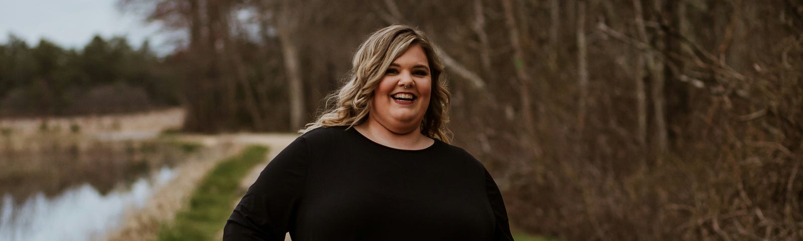 A smiling fat woman in a black dress.
